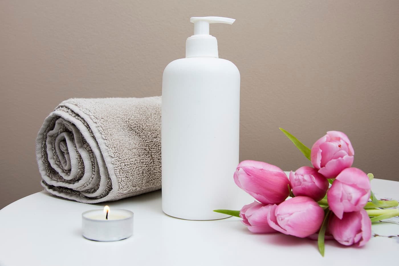 Itens de spa com toalha, creme e flores