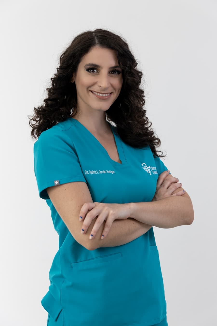 Dentista sorrindo em jaleco, no consultório